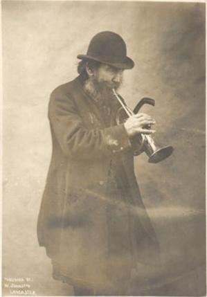 Street musician plays trumpet, Lancaster, UK, c. 1908 (image)