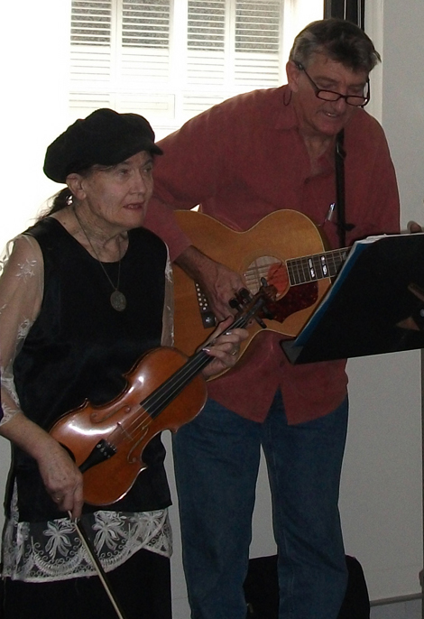 Guitarist and violinist play carols (image)